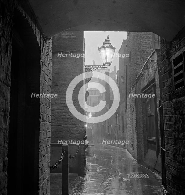 A dimly lit alley in London's theatre land off St Martin's Lane, early 1960s.  Creator: John Gay.