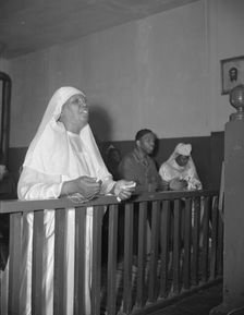 A disciple of the St. Martin's Spiritual Church praying before the altar..., Washington, D.C., 1942. Creator: Gordon Parks