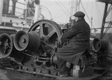 A docker operates a winching gear in London Docks, London, c1945-c1965. Artist: SW Rawlings