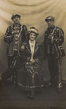 A drag pearly queen and her two kings pose for a group portrait, (between 1910 and 1919?). Creator: Unknown
