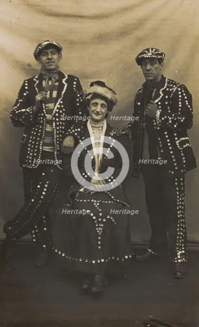 A drag pearly queen and her two kings pose for a group portrait, (between 1910 and 1919?). Creator: Unknown.