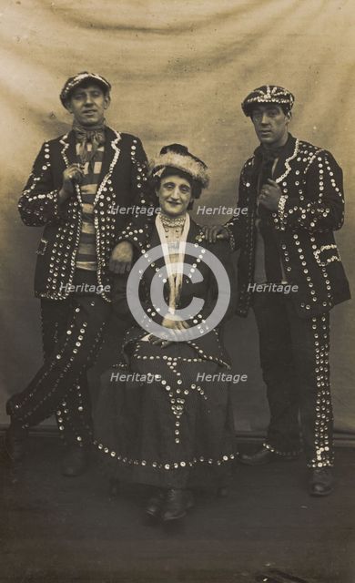 A drag pearly queen and her two kings pose for a group portrait, (between 1910 and 1919?). Creator: Unknown.