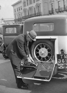 A driver opening the fitted toolkit of his Ford Model A at the Southport Rally, 1928. Artist: Bill Brunell