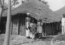 A family in front of their home, Gambia, 20th century