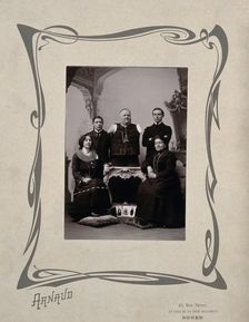 A family portrait: a man without arms and legs poses on a table surrounded by family, 20th Century. Creator: Unknown