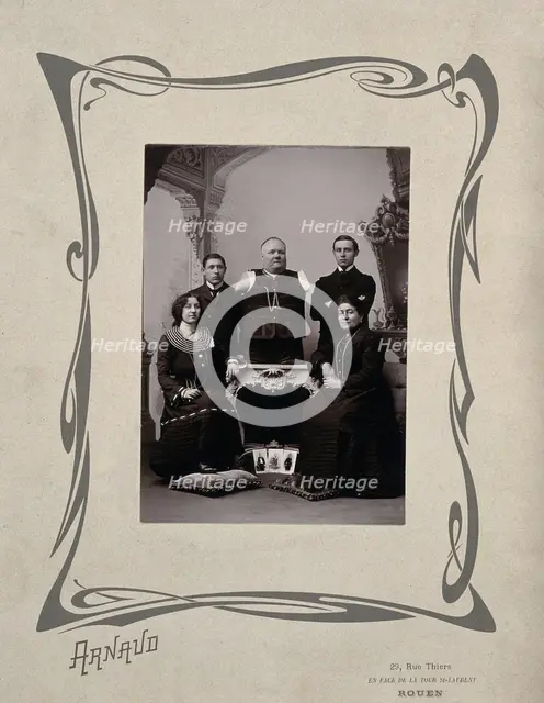 A family portrait: a man without arms and legs poses on a table surrounded by family, 20th Century. Creator: Unknown.