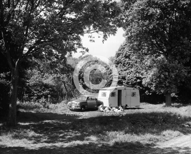 A family relaxing on holiday with their 1951 Vauxhall Wyvern and caravan, (1951?). Artist: Unknown