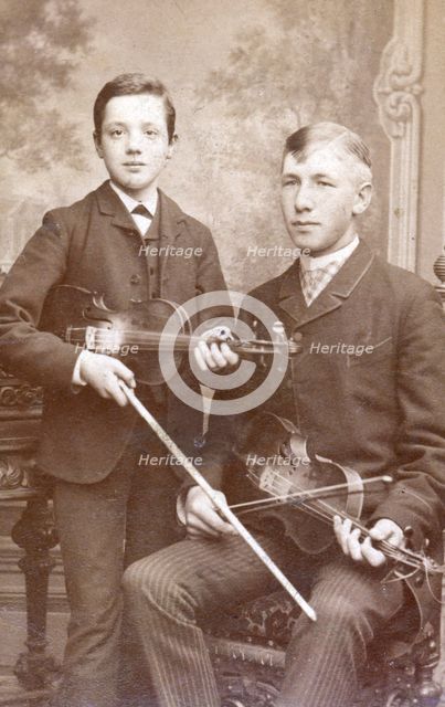 A father and son posing with their violins. Creator: Unknown.