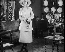 A Female Civilian Modelling a Two Piece Suit and Hat Posing in a Drawing Room, 1920. Creator: British Pathe Ltd