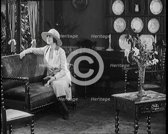 A Female Civilian Modelling a Two Piece Suit and Hat Sitting on a Sofa by a Window in a Draw... 1920 Creator: British Pathe Ltd.