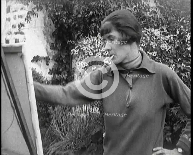 A Female Civilian Painting at an Easel Outdoors Smoking a Cigarette, 1920. Creator: British Pathe Ltd.