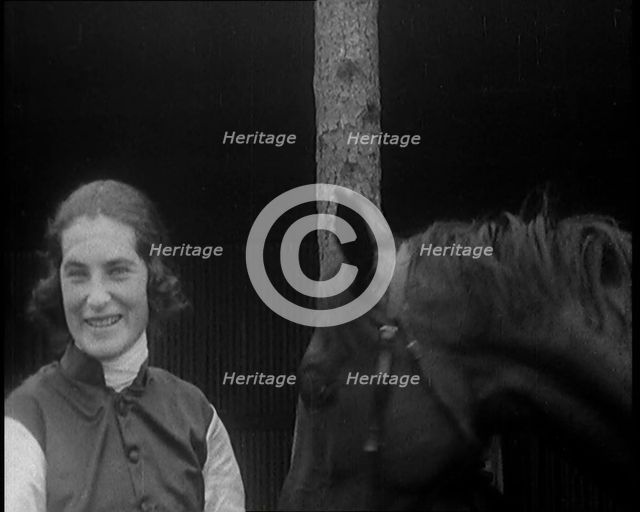 A Female Civilian Wearing a Jockey's Outfit Removing Her Hat in Front of Her Horse and..., 1920. Creator: British Pathe Ltd.