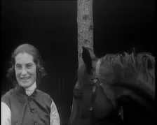 A Female Civilian Wearing a Jockey's Outfit Removing Her Hat in Front of Her Horse and..., 1920. Creator: British Pathe Ltd