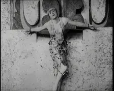 A Female Actor Chained to a Wall for a Performance, She Is Wearing a Glamorous Dress, 1922. Creator: British Pathe Ltd