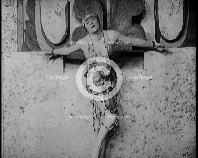 A Female Actor Chained to a Wall for a Performance, She Is Wearing a Glamorous Dress, 1922. Creator: British Pathe Ltd.