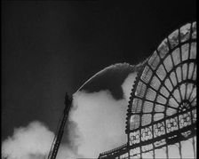 A Firefighter on a Ladder Trying to Extinguish the Crystal Palace Fire, 1936. Creator: British Pathe Ltd