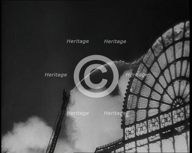 A Firefighter on a Ladder Trying to Extinguish the Crystal Palace Fire, 1936. Creator: British Pathe Ltd.