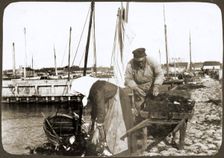 A fisherman and his wife with nets and a wheelbarrow, Borstahusen, Landskrona, Sweden, 1905. Creator: Unknown