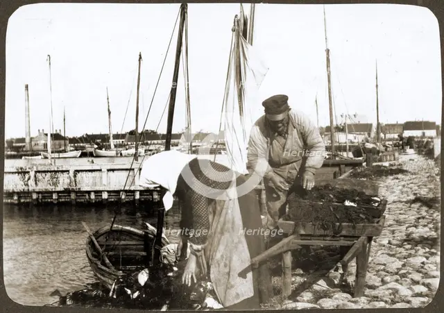 A fisherman and his wife with nets and a wheelbarrow, Borstahusen, Landskrona, Sweden, 1905. Creator: Unknown.