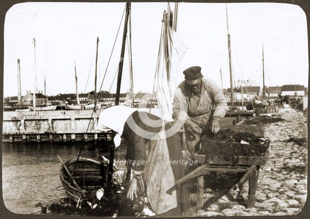 A fisherman and his wife with nets and a wheelbarrow, Borstahusen, Landskrona, Sweden, 1905. Creator: Unknown.
