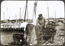 A fisherman and his wife with nets and a wheelbarrow, Borstahusen, Landskrona, Sweden, 1905