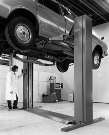A Ford Zodiac on a Laycock asymmetric lift, 1972. Creator: Michael Walters