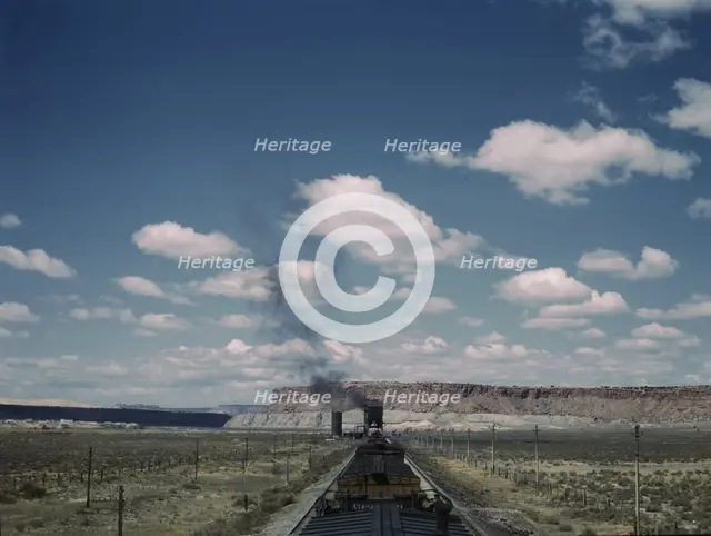 A freight train stopping for coal and water at a siding enroute to Gallup, New Mexico, 1943. Creator: Jack Delano.