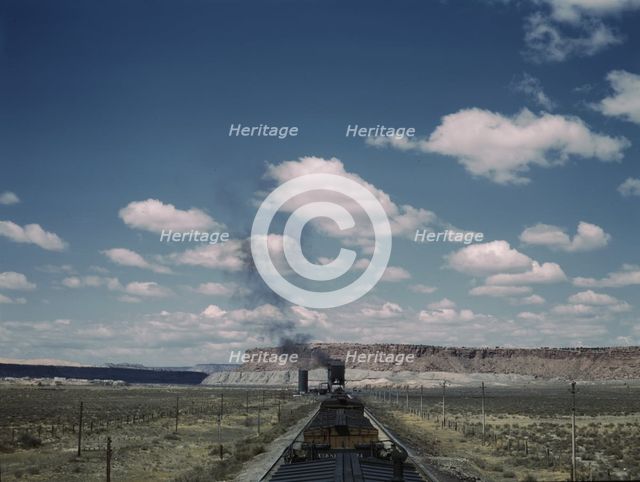 A freight train stopping for coal and water at a siding enroute to Gallup, New Mexico, 1943. Creator: Jack Delano.