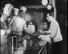 A Galley With Kitchen Staff Cooking and Waiters With Dishes on Board the Strength Through..., 1939. Creator: British Pathe Ltd