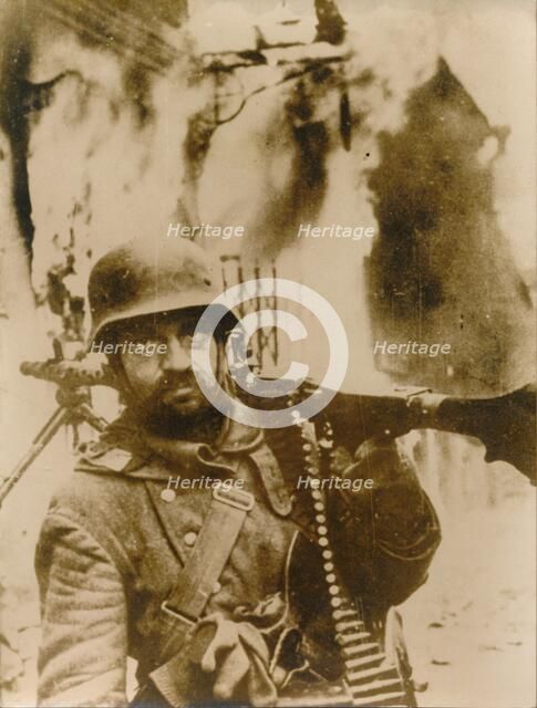 A German soldier standing in a burning Russian village. Artist: Unknown