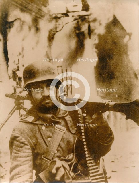 A German soldier standing in a burning Russian village. Creator: Unknown.