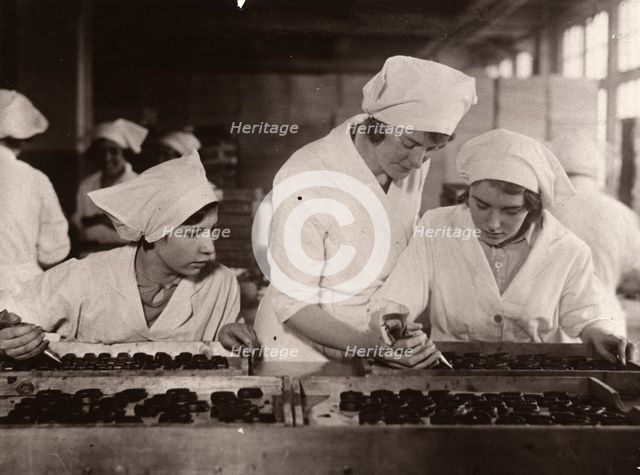 A girl is taught how to hand-pipe chocolates, Rowntree factory, York, Yorkshire, 1933. Artist: Unknown