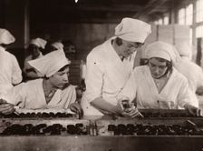 A girl is taught how to hand-pipe chocolates, Rowntree factory, York, Yorkshire, 1933