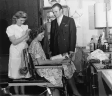 A girl passing the test to qualify as a hairdresser before a male inspector, Sweden, c1940-1959. Creator: Unknown