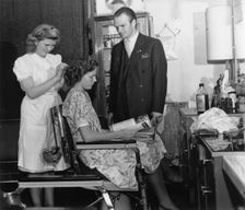A girl passing the test to qualify as a hairdresser before a male inspector, Sweden, c1940-1959. Creator: Unknown