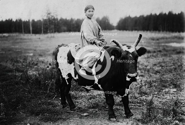 A girl riding a bull, 1890. Creator: Unknown.