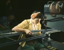 A girl riveting machine operator at the Douglas Aircraft Company plant..., Long Beach, Calif. , 1942 Creator: Alfred T Palmer