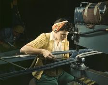 A girl riveting machine operator at the Douglas Aircraft Company plant..., Long Beach, Calif. , 1942 Creator: Alfred T Palmer