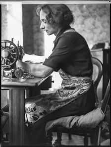 A glover or glove maker working at a sewing machine, Woodstock, Oxfordshire, 1920-1940. Creator: George R Long