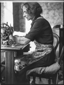 A glover or glove maker working at a sewing machine, Woodstock, Oxfordshire, 1920-1940. Creator: George R Long