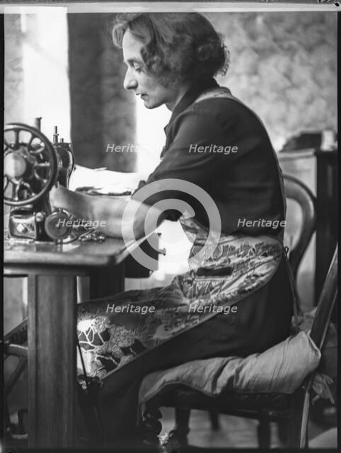 A glover or glove maker working at a sewing machine, Woodstock, Oxfordshire, 1920-1940.  Creator: George R Long.