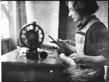 A glover or glove maker working at a sewing machine, Woodstock, Oxfordshire, 1920-40. Creator: George R Long