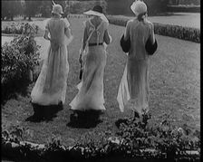 A Group of Three Female Civilians Wearing Fashionable Clothes Standing in a Garden, 1929. Creator: British Pathe Ltd
