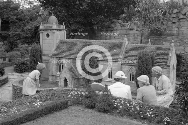 A group of women and a child admire the church in the model village at Corfe Castle, c1945-c1965. Artist: SW Rawlings