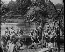 A Group of Young Civilians Wearing Swimsuits Seating on a Boat on Riverside, 1920. Creator: British Pathe Ltd