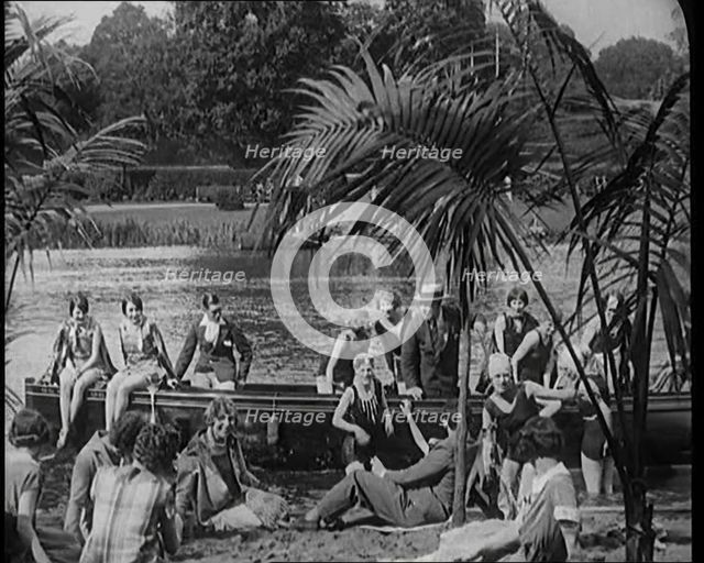 A Group of Young Civilians Wearing Swimsuits Seating on a Boat on Riverside, 1920. Creator: British Pathe Ltd.