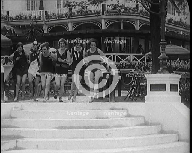 A Group of Young Female Civilians Running down Some Steps Wearing Swimsuits, 1920. Creator: British Pathe Ltd.