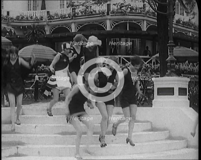 A Group of Young Female Civilians Running down Some Steps Wearing Swimsuits, 1920. Creator: British Pathe Ltd.