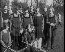A Group of Young Female Civilians Wearing Gymslips Holding Lacrosse Sticks, 1920. Creator: British Pathe Ltd