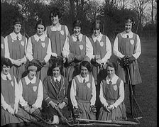 A Group of Young Female Civilians Wearing Gymslips Holding Lacrosse Sticks, 1920. Creator: British Pathe Ltd